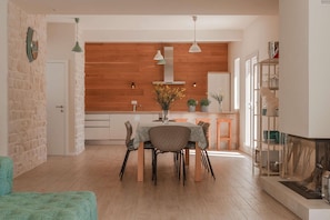 Enjoy meals in this open dining area with a central table for four and a view into the adjacent kitchen.
