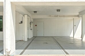 Un espace intérieur propre et dégagé, avec une porte, des murs blancs et un sol en béton.