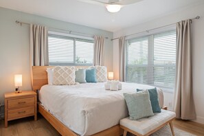 Une chambre à coucher avec un lit, des tables de chevet et un banc.