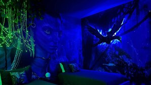 A room with two green sofas, a large aquarium with fish, and a wall mural. - Last Minute Disney! Private Pool, Hot Tub, Game Room & Themed Bedrooms. Book Now! #60031 (Orlando)