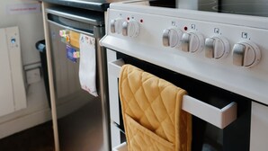 A kitchen with a stove, oven, and various utensils on the wall. - woodland cottage (barnstaple)
