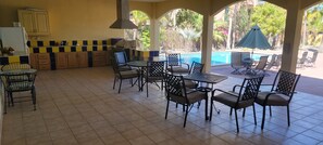 A covered outdoor area with a pool, dining tables, chairs, and a barbecue grill. - Oceanview Getaway, Large Beach House w/ Pool, Hot Tub & 2 Kitchens (Loreto)