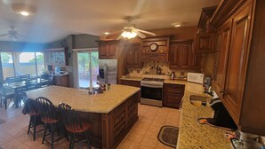 A spacious kitchen with a large island, wooden cabinets, and a built-in oven.