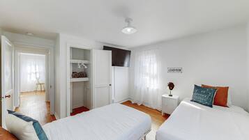 A room with two beds, a wardrobe, a small table with a lamp, and a sign indicating a locker room.
