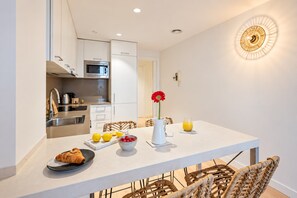 A modern kitchen with white cabinets, a stainless steel sink, and a microwave. - Sweett | Girona 303 - One Bedroom Apartment, Sleeps 4 (Barcelona)