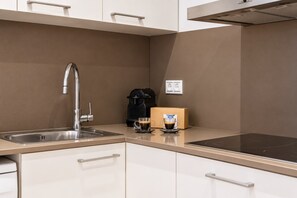 A modern kitchen with a stainless steel sink, a coffee maker, and a box of coffee pods. - Sweett | Girona 401 - Three Bedroom Apartment, Sleeps 7 (Barcelona)
