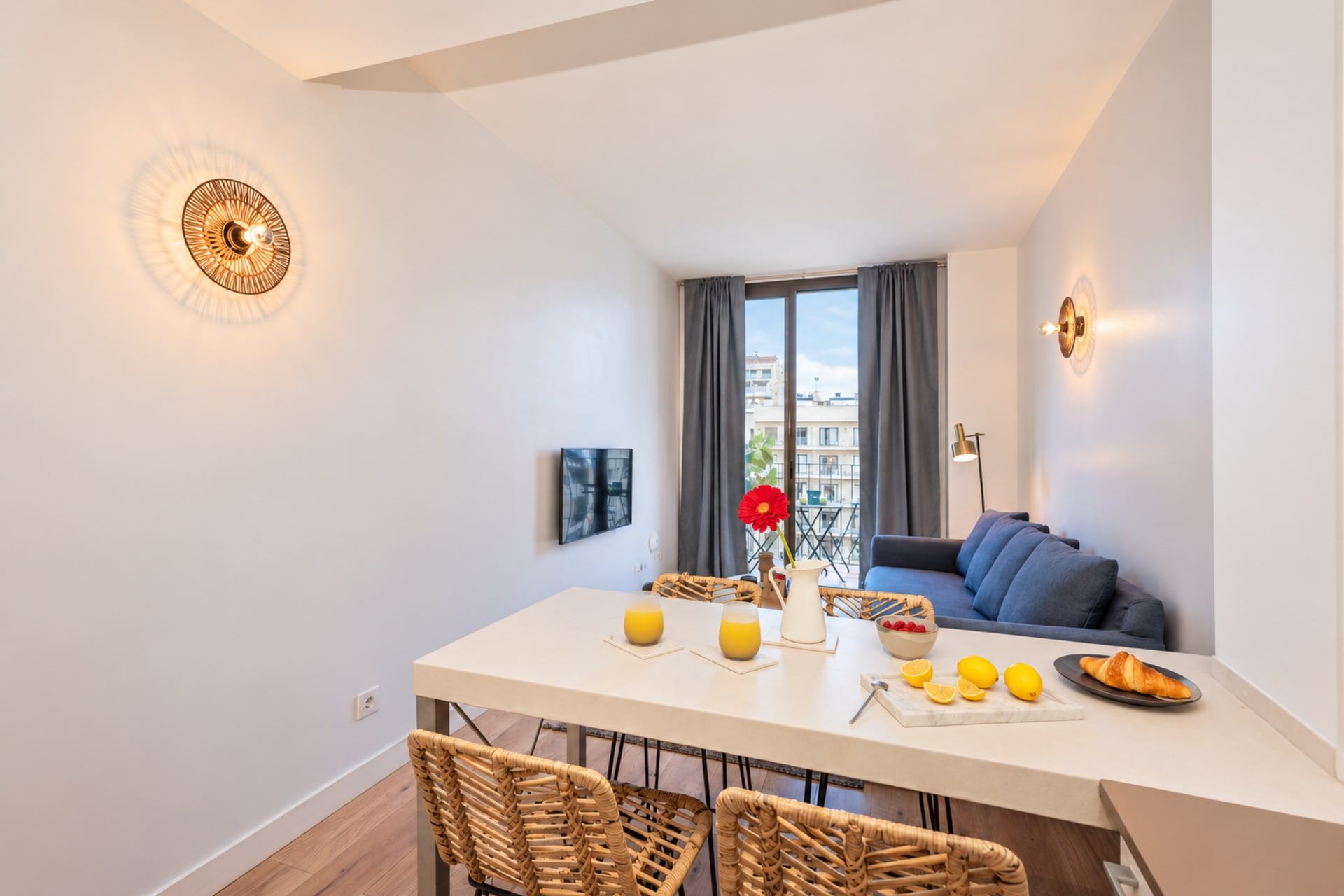 Un espacio moderno para vivir con comedor, sofá y vista a la ciudad.