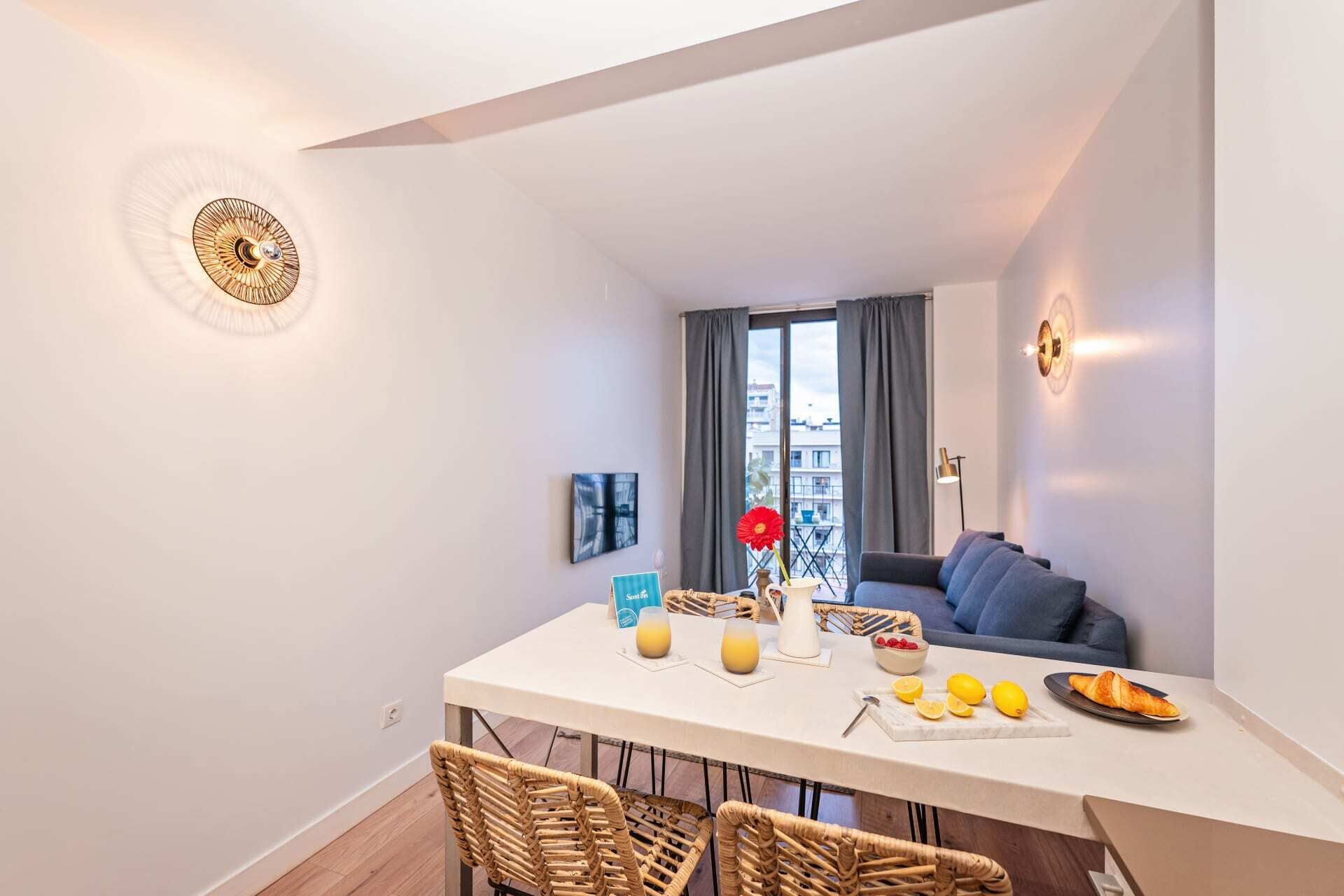 Un apartamento moderno con comedor, sofá y vistas de la ciudad.