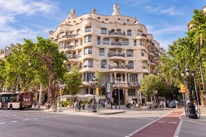 A multi-story building with balconies, a street in front, and trees. - Sweett | Girona 403 - One Bedroom Apartment, Sleeps 4 (Barcelona)