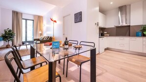 A modern apartment with a dining area, kitchen, and living space. - Sweett | Girona 501 - Three Bedroom Apartment, Sleeps 7 (Barcelona)