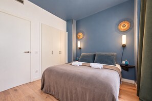 A bedroom with a bed, bedside tables, wall-mounted lamps, and a wardrobe. - Sweett | Girona 503 - One Bedroom Apartment, Sleeps 4 (Barcelona)