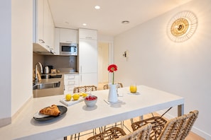 A modern kitchen with white cabinets, a stainless steel sink, and a microwave. - Sweett | Girona 503 - One Bedroom Apartment, Sleeps 4 (Barcelona)