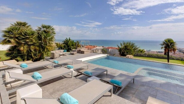 A poolside area with lounge chairs and a view of the sea. - Villa "Atalaya" with Sea View, Private Pool & Wi-Fi (Peñíscola)