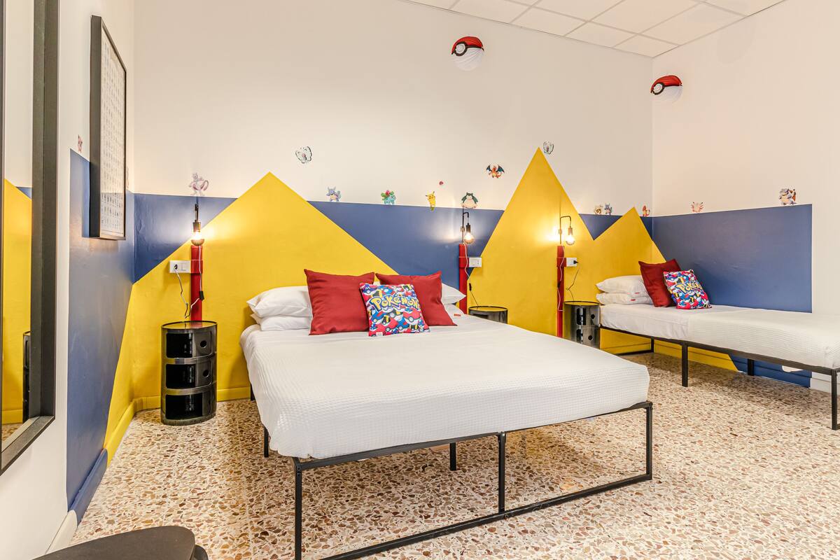 Habitación de hotel con dos camas, un reloj de pared y un pequeño estante.