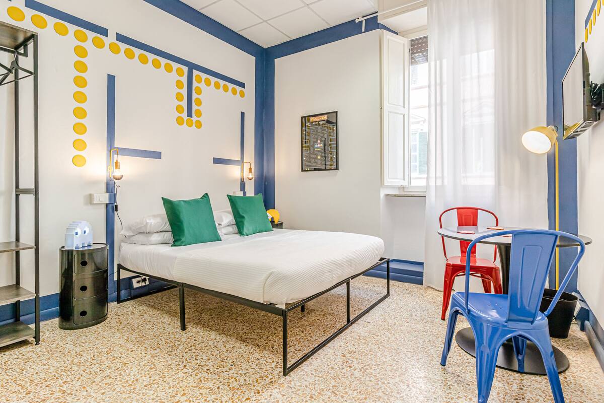 Un dormitorio con cama, escritorio, silla y un diseño de placa de circuito en la pared.