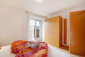 Une chambre à coucher avec un lit, une armoire et une fenêtre avec des rideaux.