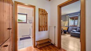 A hallway with wooden flooring, a bench, a radiator, and a window with a view. - Apartment "Mosttragerhof 3" with Mountain View, Shared Pool & Wi-Fi (Scena)