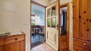 A room with a wooden desk, a door leading to an outdoor area with a table and chairs, and a wooden wardrobe. - Apartment "Mosttragerhof 3" with Mountain View, Shared Pool & Wi-Fi (Scena)