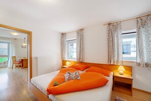 Hotelkamer met een bed, nachtkastjes, een raam met gordijnen, een radiator en uitzicht.