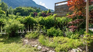 Un jardín con diversas plantas y una valla de madera.