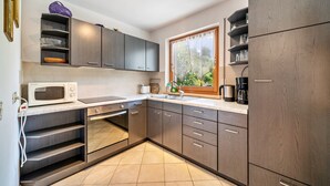 Una cucina moderna con elettrodomestici integrati, una finestra con vista e un pavimento piastrellato.
