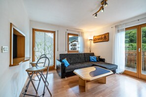 Un salon moderne comprenant un canapé, une table basse et un coin repas avec des chaises.
