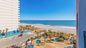 Un hotel con piscina, vista a la playa y estacionamiento.