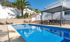 A swimming pool with lounge chairs and a patio area.
