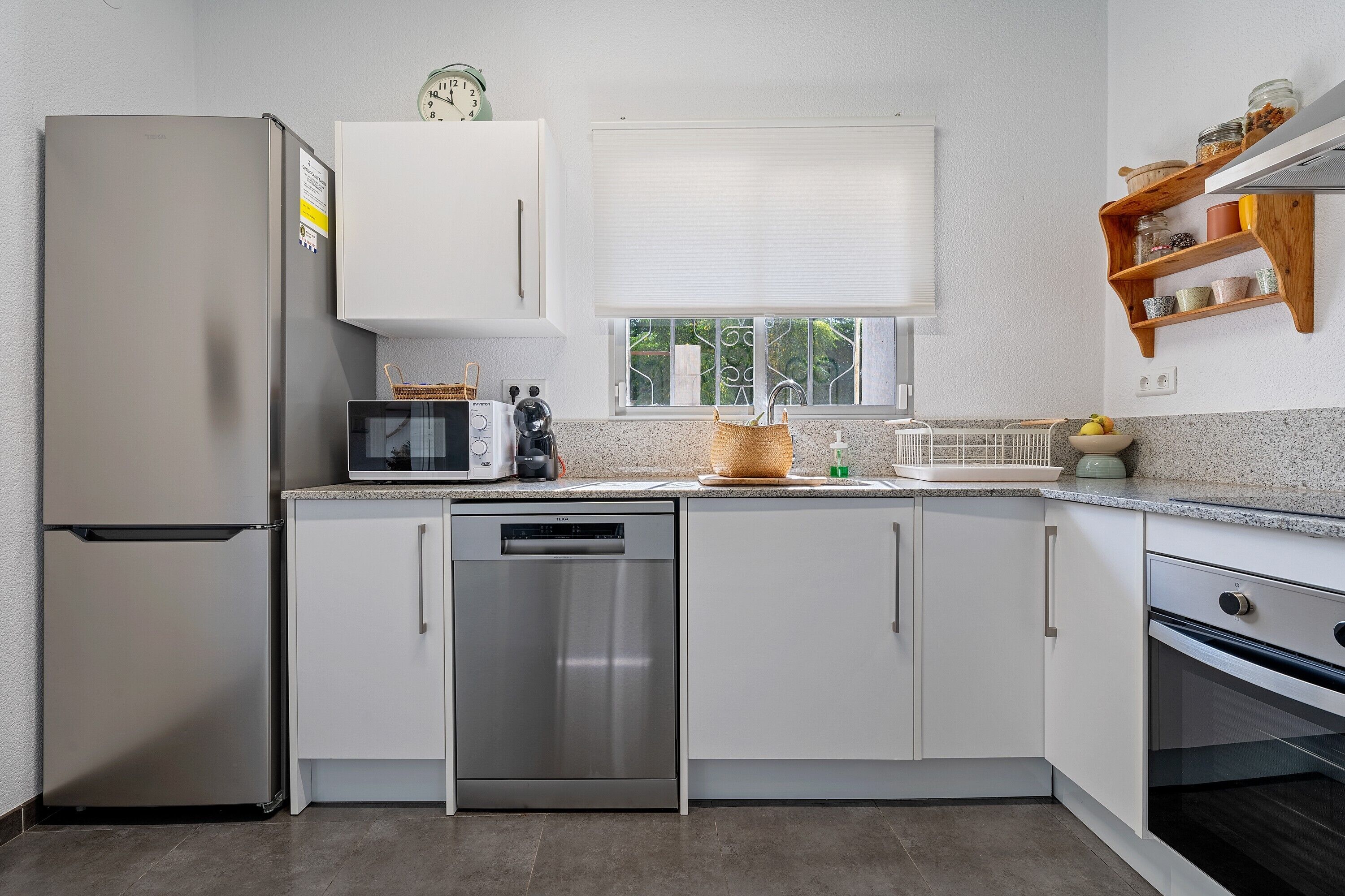 A modern kitchen with a refrigerator, dishwasher, microwave, and oven.