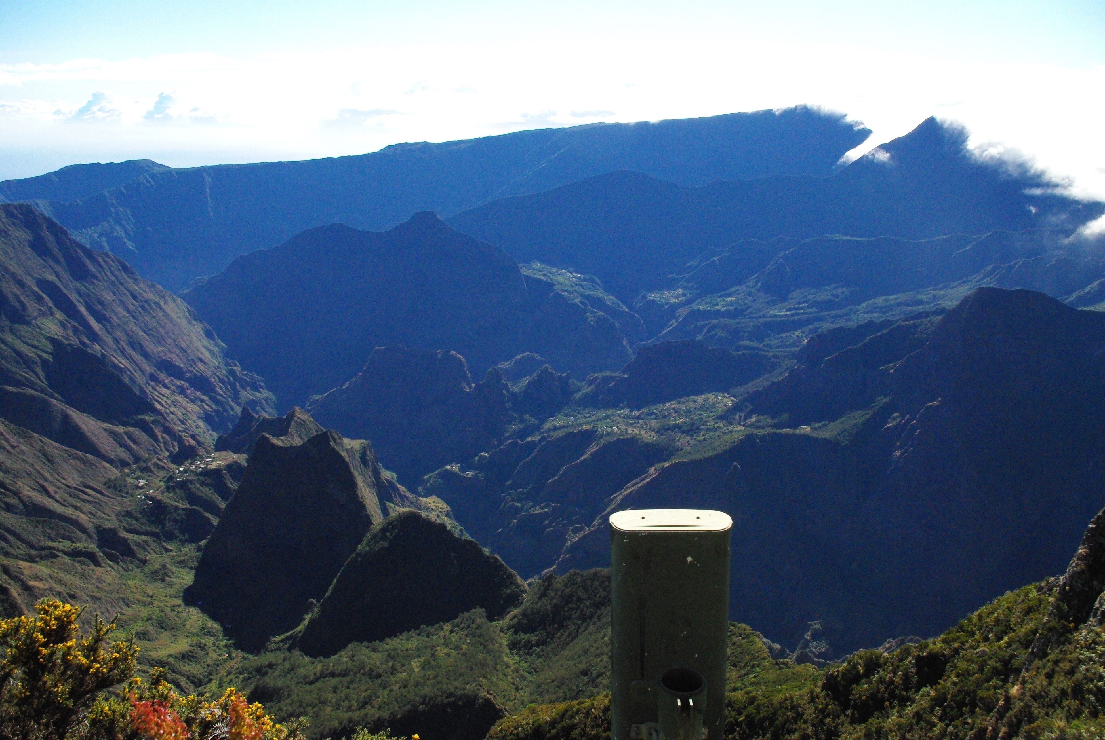 A mountainous landscape with a prominent rock structure in the foreground.