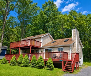 A two-story house with a red deck, a chimney, and a number '139' on the front.