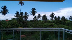 Un balcón con vistas a palmeras y vegetación exuberante.