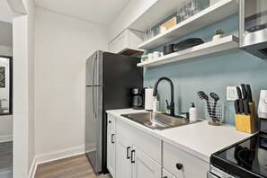 A modern kitchen with a stainless steel refrigerator, a sink, and a coffee maker.