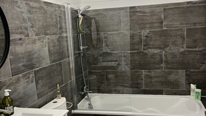 Un baño moderno con ducha, inodoro y lavamanos.