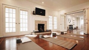 A spacious room with a fireplace, wooden flooring, and a large mirror. - The 212 Escape (Woodstock)