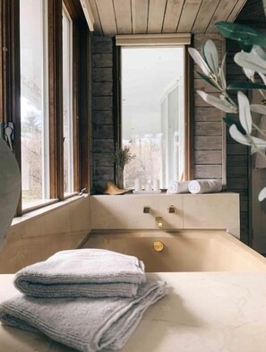 Une salle de bain moderne avec une grande fenêtre, une baignoire et un lavabo.