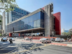 A modern building with large windows and a covered pedestrian walkway. - Next AW Franca by Viva - Prédio novo ao lado da Av Paulista (São Paulo)