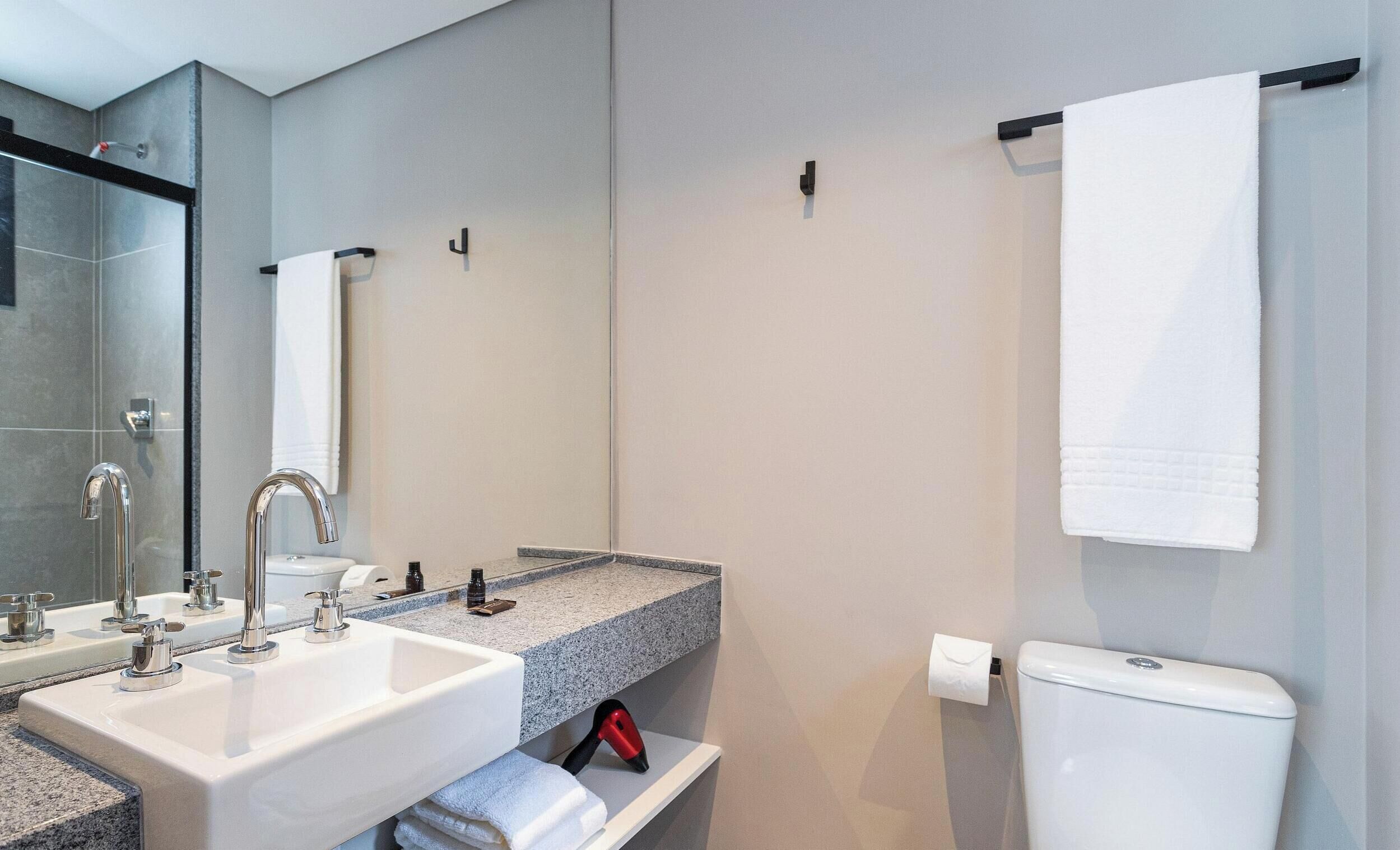 Une salle de bain moderne avec un lavabo, un miroir et des toilettes.