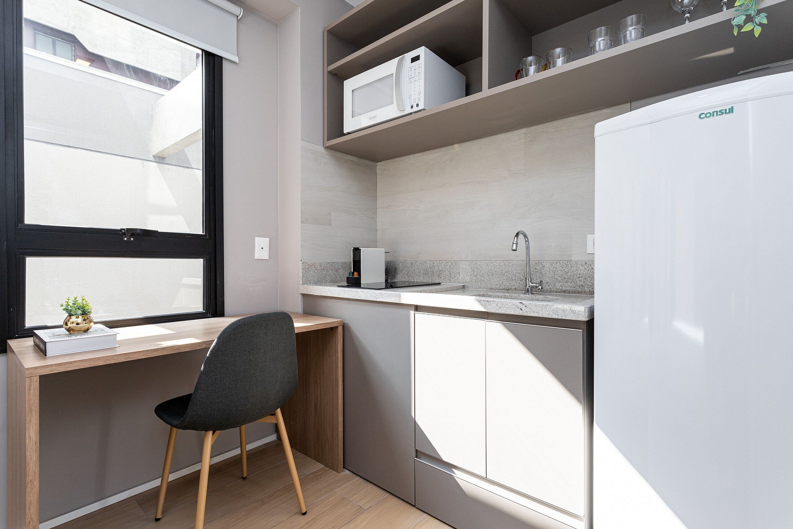 A compact kitchen with a microwave, a sink, and a refrigerator.