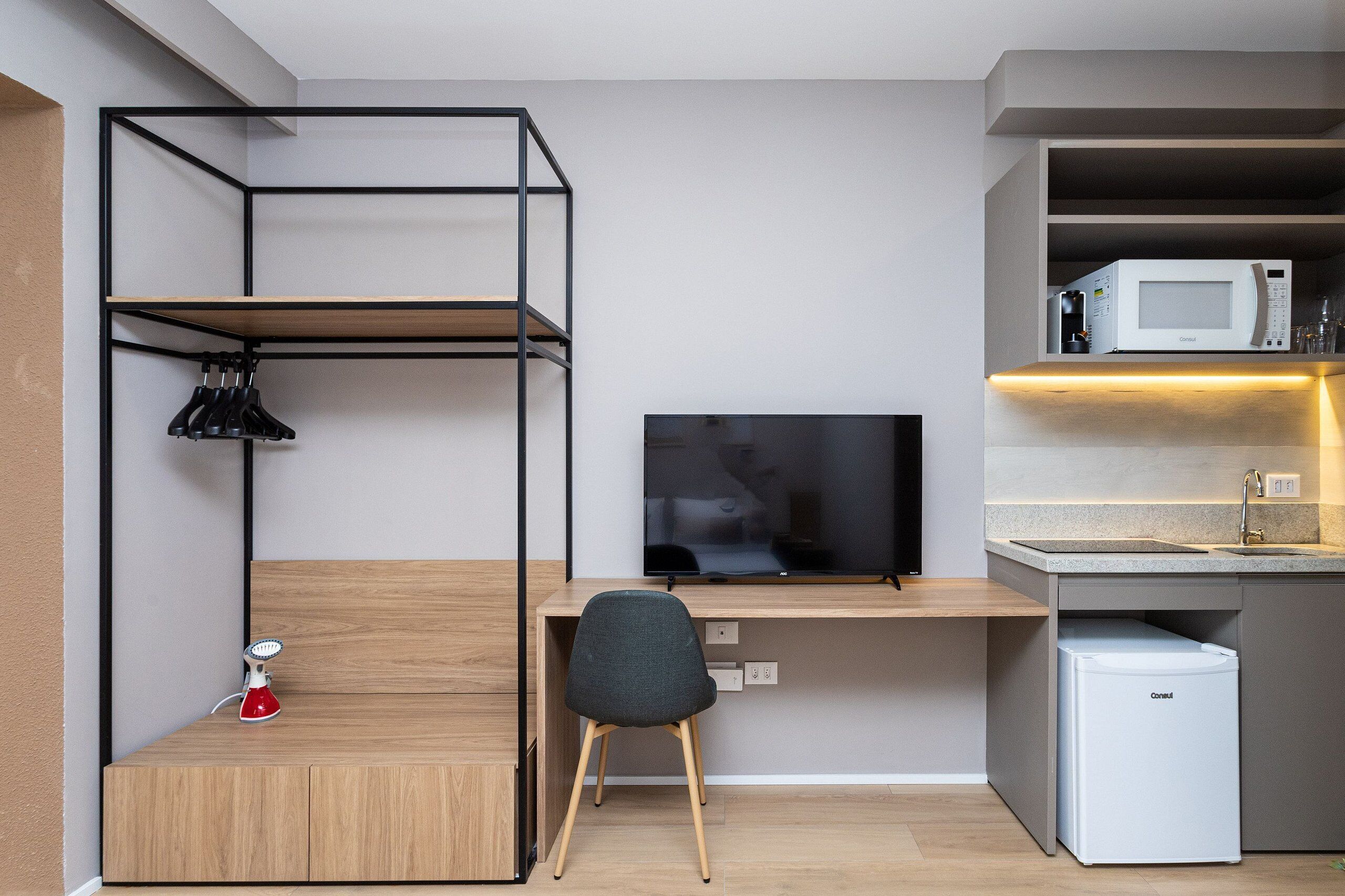 A compact kitchenette with a microwave, sink, and storage cabinet.