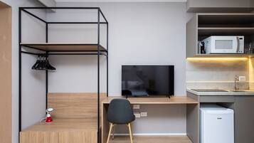 A compact kitchenette with a microwave, sink, and storage cabinet.