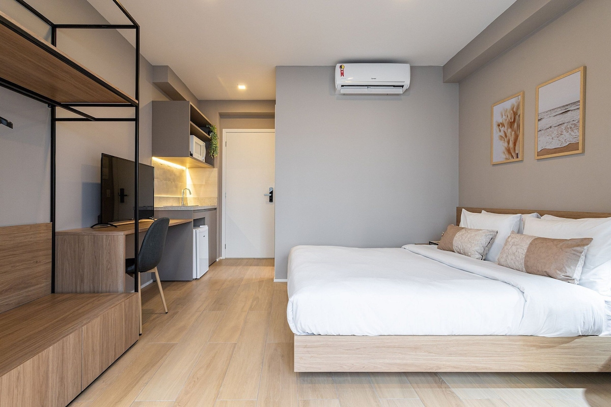Ein modernes Schlafzimmer mit Bett, Schreibtisch, Stuhl und Einbauschränken.