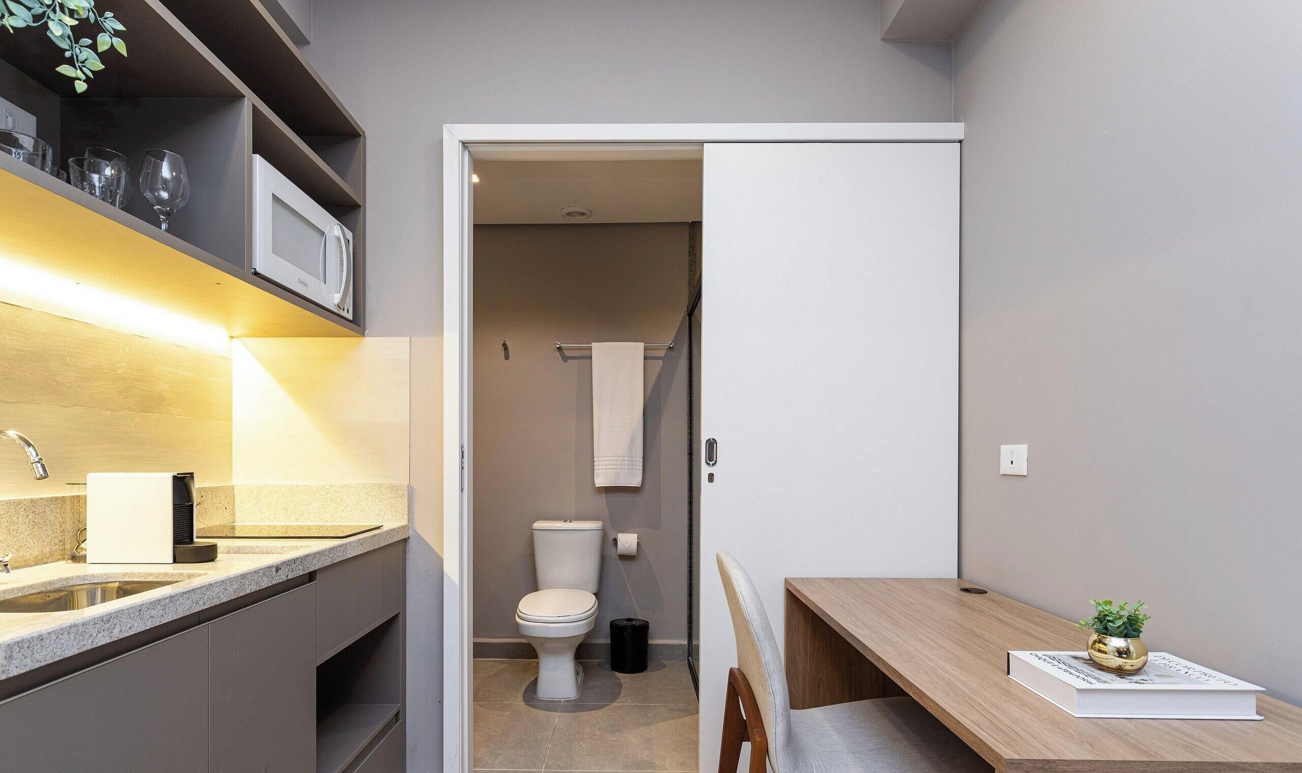 A compact kitchen with a sink, a microwave, and a countertop.