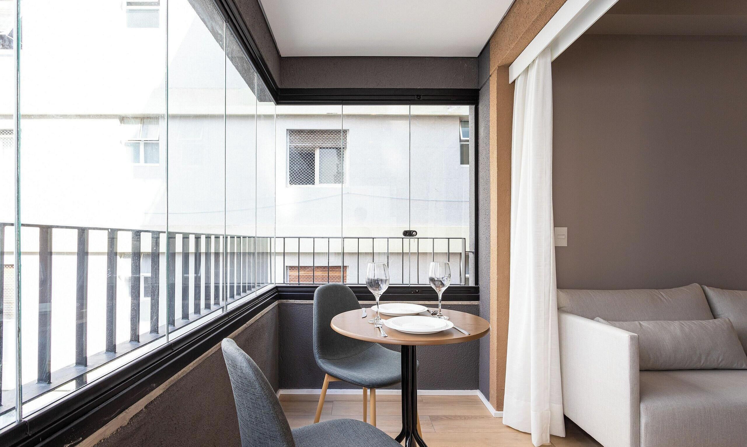 Un balcon avec une table et des chaises, un canapé et une vue sur la ville.