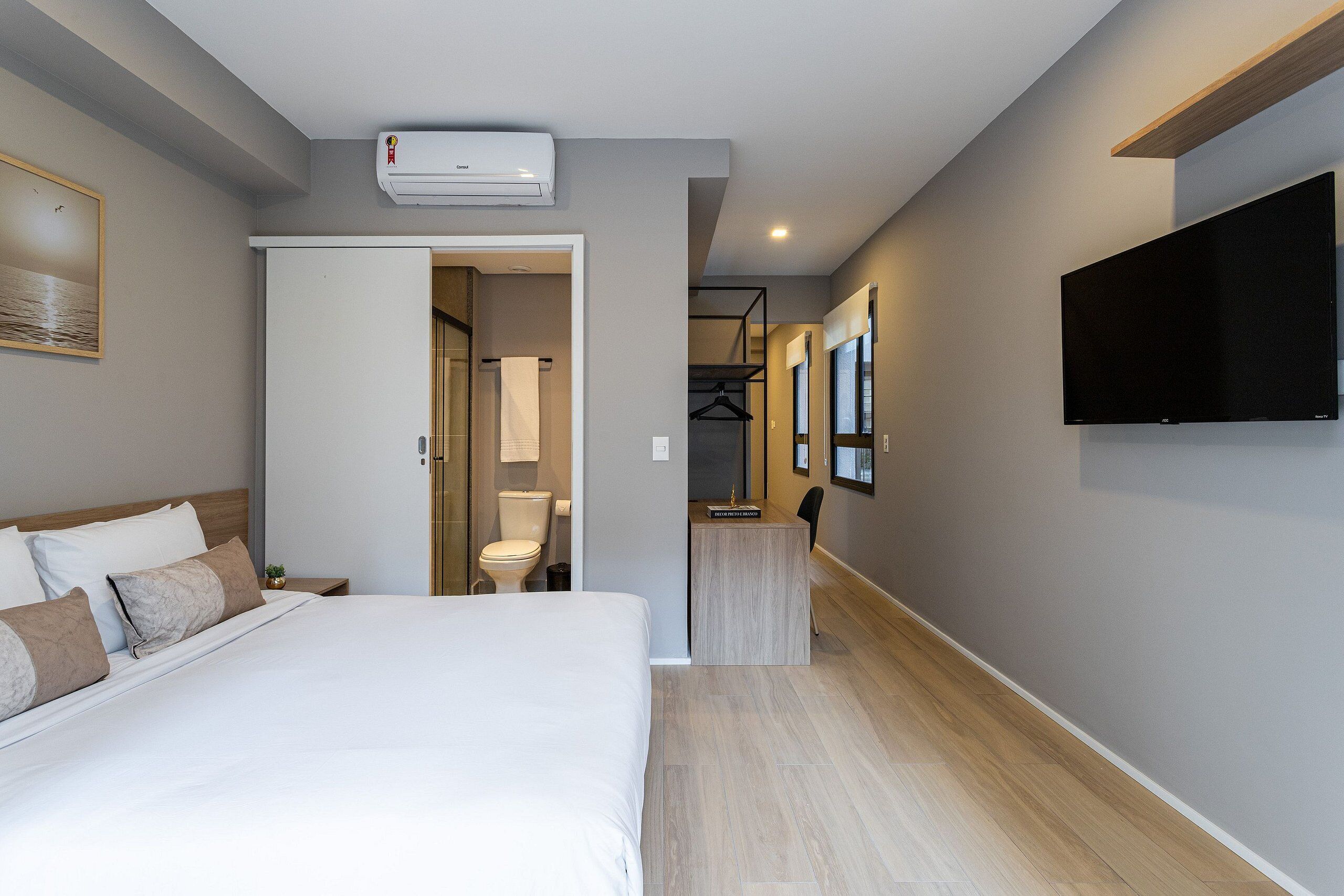 Una habitación de hotel con cama, televisión, escritorio y baño.