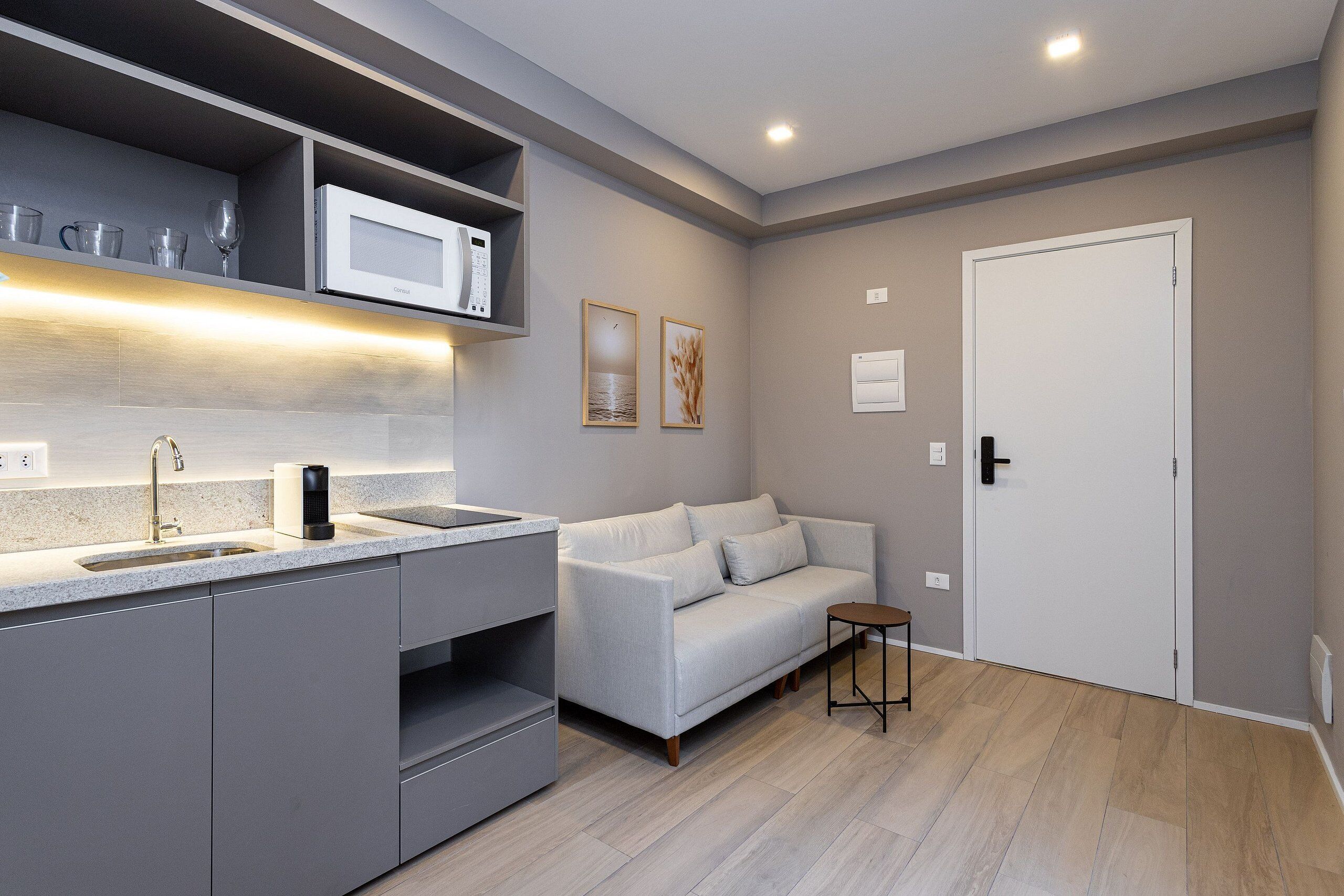 A modern kitchen with a built-in microwave, a sink, and a small table.
