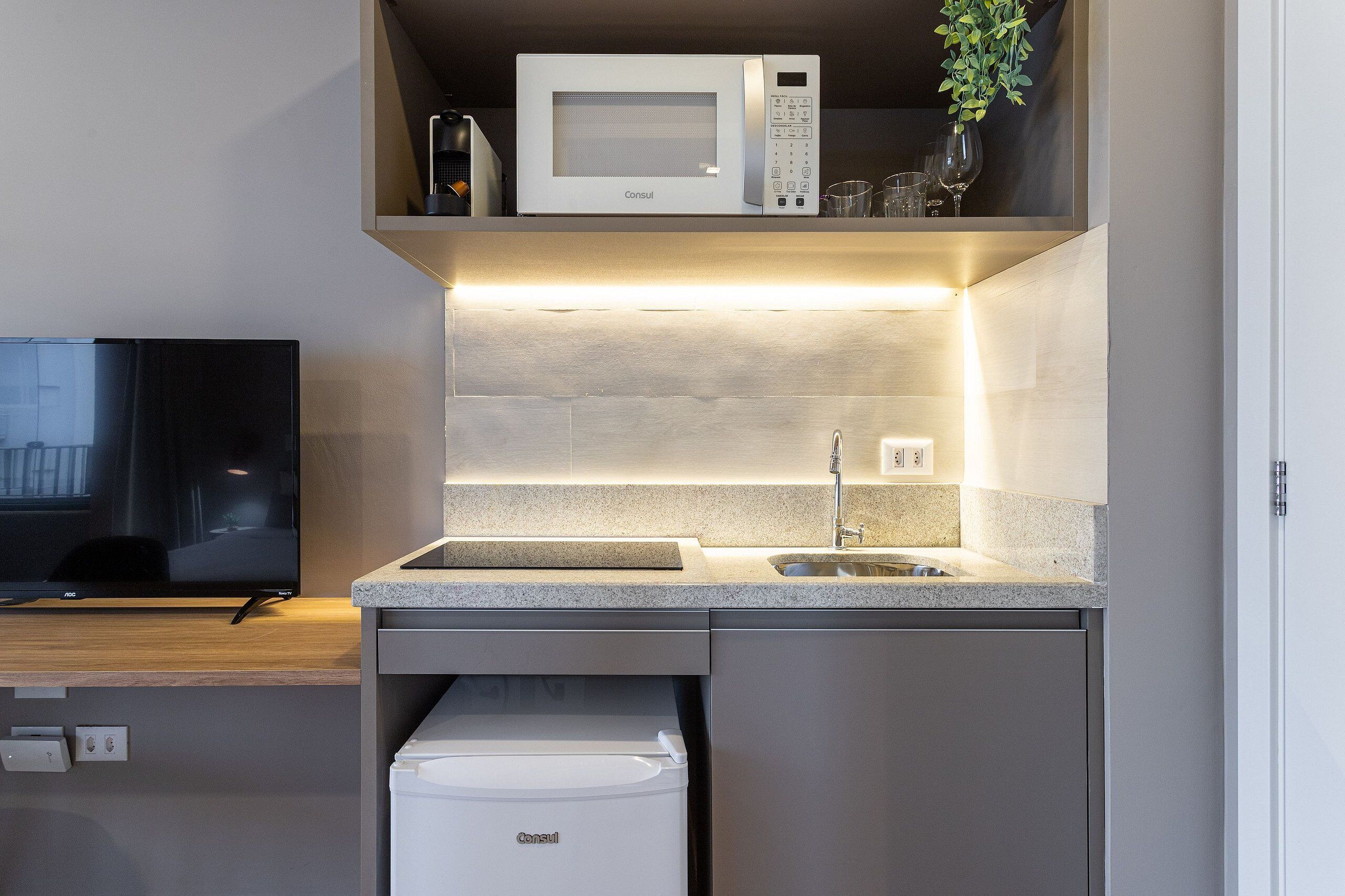 A modern kitchen with a microwave, sink, and built-in dishwasher.