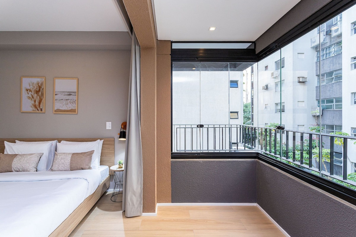 Une chambre à coucher avec un lit, une table de chevet, une fenêtre et un balcon.