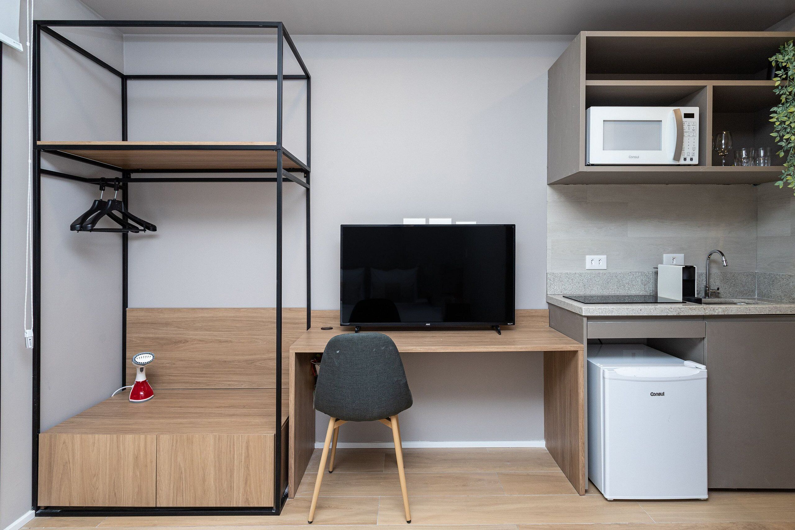 Una kitchenette compacta con microondas, lavabo y refrigerador.