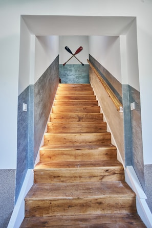 Stairs lead up to a landing with two paddles on the wall.